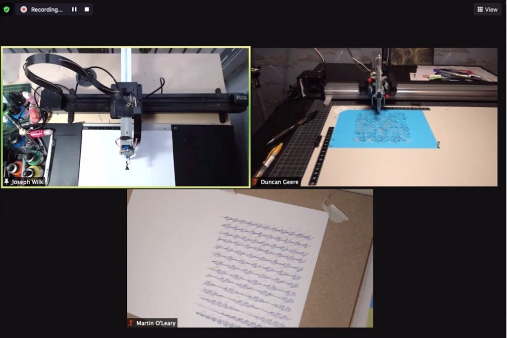 Screenshot of a video call which shows mechanical arms drawing onto paper.